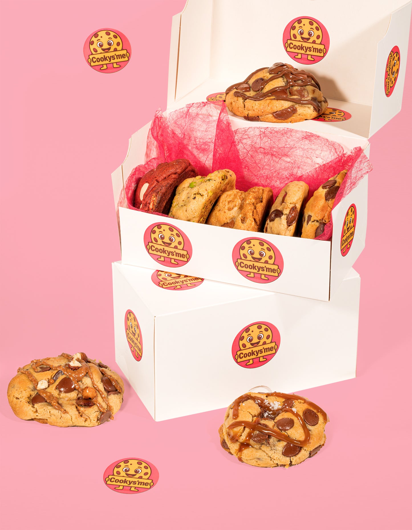 Box découverte cookys'me ouverte avec huit cookies artisanaux aux saveurs variées, présentée sur fond rose - cookies fait maison et gourmands