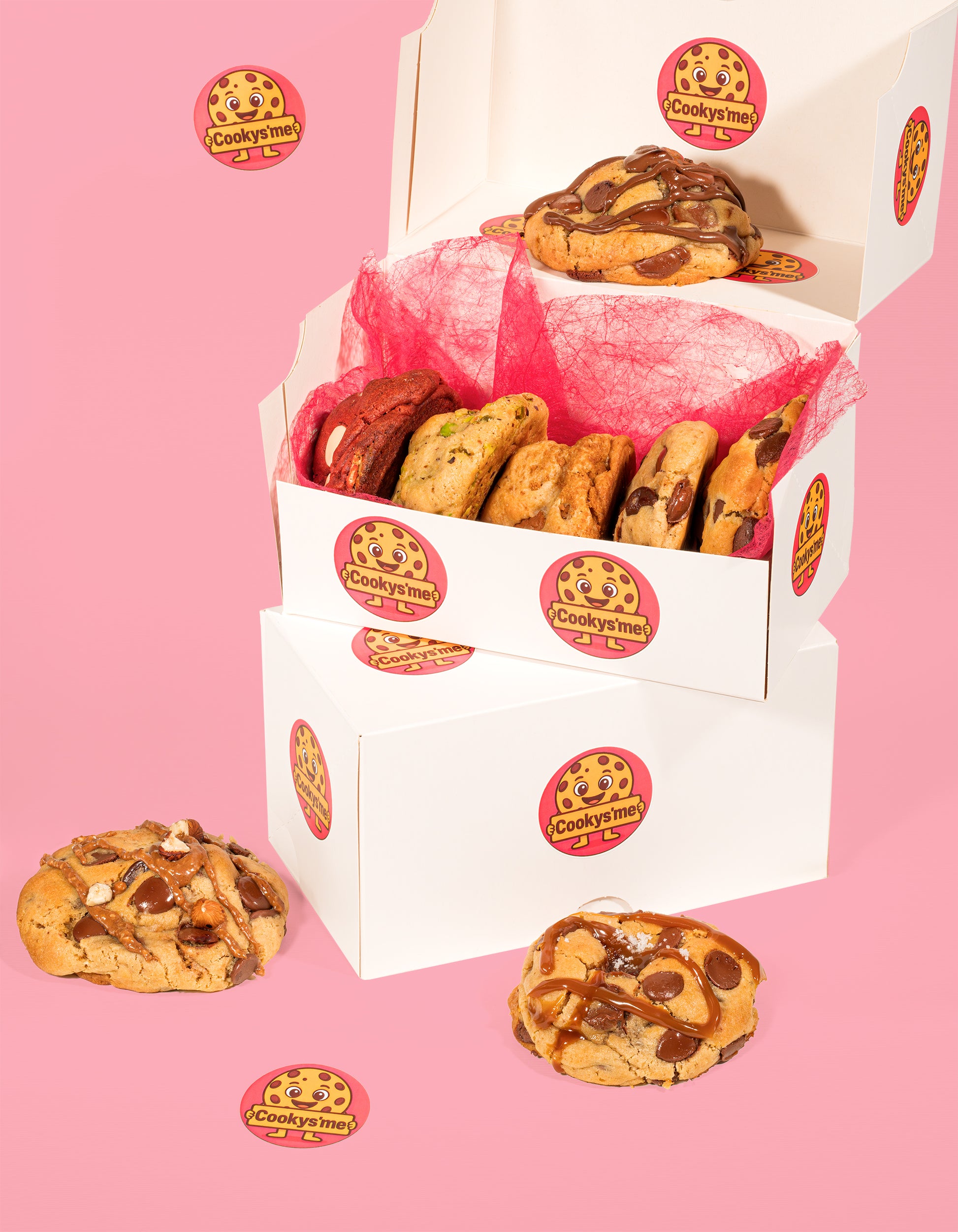 Box découverte cookys'me ouverte avec huit cookies artisanaux aux saveurs variées, présentée sur fond rose - cookies fait maison et gourmands