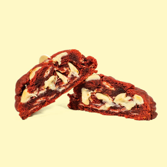 Cookie fait maison moelleux red velvet rouge, au chocolat blanc, coupé en deux pour montrer l'intérieur fondant